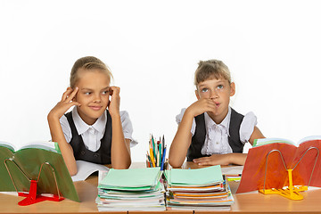 Image showing Two girls thought about an abstract topic while sitting at a desk at school