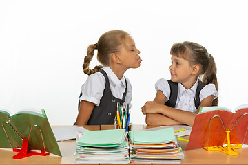 Image showing Girl at her desk showed tongue to another girl