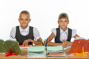 Image showing Two schoolgirls gaze intently and emotionlessly into the frame