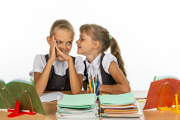 Image showing Girlfriend at school desk tells something interesting on the ear