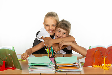 Image showing Two schoolgirls are sitting at a desk looking at textbooks