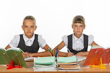 Image showing Two schoolgirls gaze intently and emotionlessly into the frame