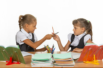Image showing Two girls fight with pencils at a school desk