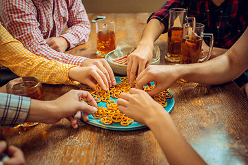 Image showing people, leisure, friendship and communication concept - happy friends drinking beer, talking and clinking glasses at bar or pub