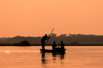 Image showing Men in a boat on a river silhouette