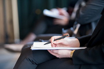 Image showing close up of business people taking notes