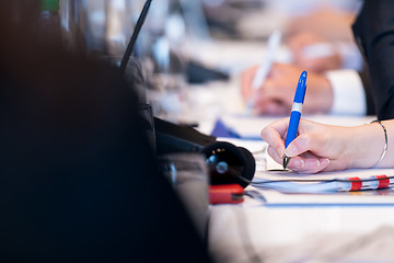 Image showing close up of business people taking notes