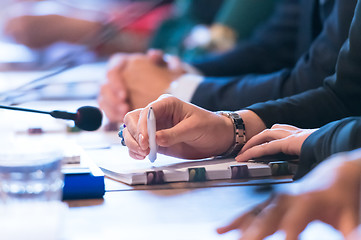 Image showing close up of business people taking notes