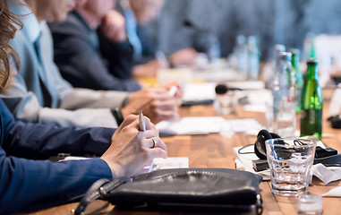 Image showing close up of business people taking notes