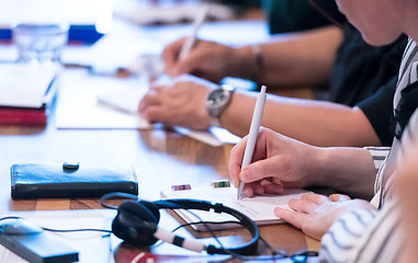 Image showing close up of business people taking notes