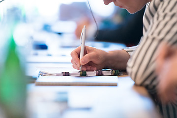 Image showing close up of business people taking notes