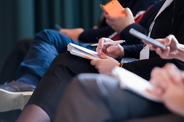 Image showing close up of business people taking notes