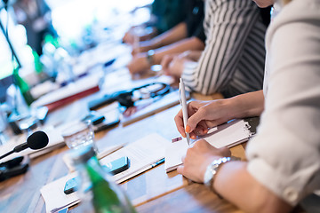 Image showing close up of business people taking notes