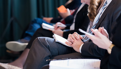 Image showing close up of business people taking notes