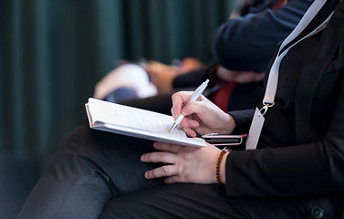 Image showing close up of business people taking notes