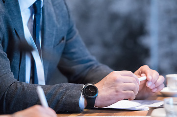 Image showing close up of business people taking notes