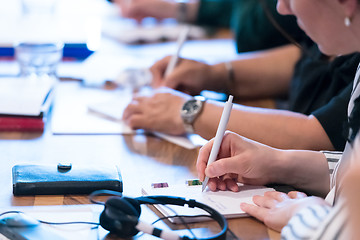 Image showing close up of business people taking notes