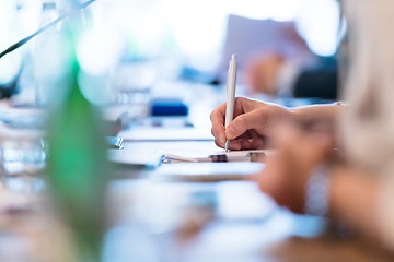 Image showing close up of business people taking notes