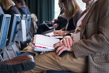 Image showing close up of business people taking notes