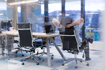 Image showing young businessman relaxing at the desk