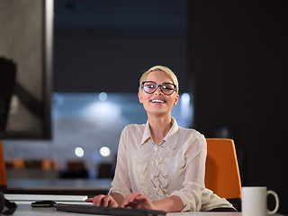 Image showing woman working on computer in dark office