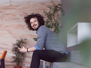 Image showing Young casual businessman holding smartphone