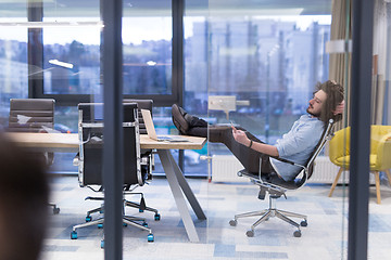 Image showing young businessman relaxing at the desk