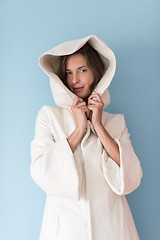 Image showing woman in a white coat with hood isolated on blue background