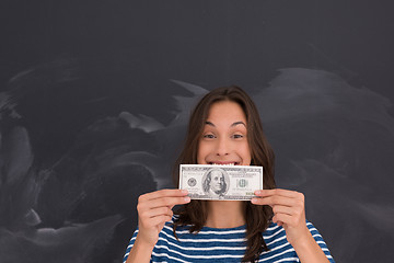 Image showing woman holding a banknote in front of chalk drawing board