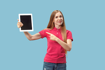 Image showing Portrait of a confident casual girl showing blank screen of laptop isolated over blue background