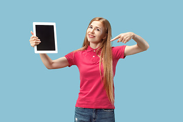 Image showing Portrait of a confident casual girl showing blank screen of laptop isolated over blue background