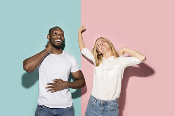 Image showing happy afro man and woman. Dynamic image of caucasian female and afro male model on pink studio.