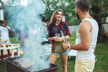 Image showing Group of friends making barbecue in the backyard. concept about good and positive mood with friends