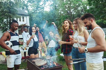 Image showing Group of friends making barbecue in the backyard. concept about good and positive mood with friends