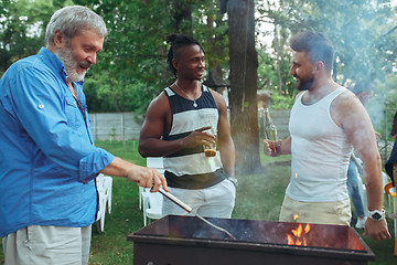 Image showing Group of friends making barbecue in the backyard. concept about good and positive mood with friends