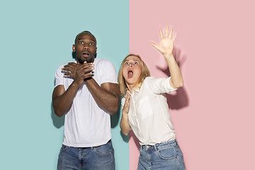 Image showing Portrait of the scared couple on pink and blue studio background