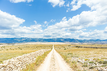 Image showing Dirt road leading trough dry rocky Mediterranean coastal lanscape of Pag island, Croatia in summertime