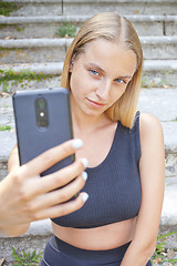 Image showing Attractive young woman taking selfie.
