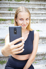 Image showing Attractive young woman in black taking selfie.