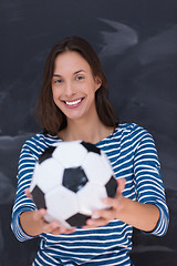 Image showing woman holding a soccer ball in front of chalk drawing board