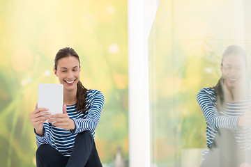 Image showing young women using tablet computer on the floor