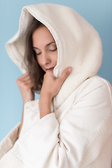 Image showing woman in a white coat with hood isolated on blue background