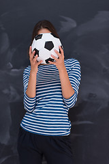 Image showing woman holding a soccer ball in front of chalk drawing board