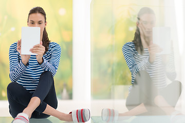 Image showing young women using tablet computer on the floor