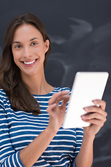 Image showing woman using tablet  in front of chalk drawing board