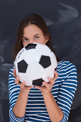 Image showing woman holding a soccer ball in front of chalk drawing board