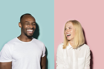 Image showing happy afro man and woman. Dynamic image of caucasian female and afro male model on pink studio.