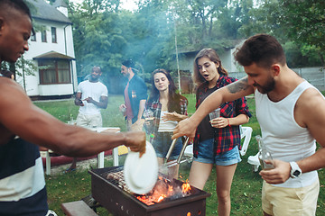 Image showing Group of friends making barbecue in the backyard. concept about good and positive mood with friends