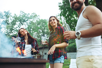 Image showing Group of friends making barbecue in the backyard. concept about good and positive mood with friends