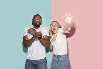 Image showing Portrait of the scared couple on pink and blue studio background